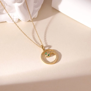 Elegante gouden slangenketting met zirkonia halo en groene edelsteen ogen voor dames