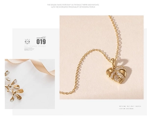 Detail of gold heart monstera leaf pendant necklace with shimmering zircon stones
