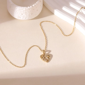 Elegant gold heart pendant necklace with leaf texture and pave-set cubic zirconia crystals