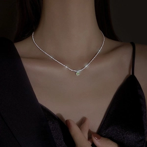 Vintage green gem pendant necklace on sparkling silver chain worn by a model
