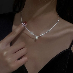 Sparkling silver choker necklace with a brilliant round pendant on elegant female model