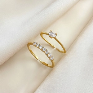 Adjustable gold heart ring set with zircon stones on an elegant silk satin background