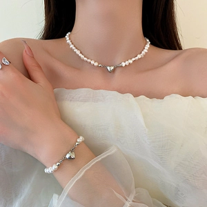 Ensemble collier et bracelet perles avec fermoir magnétique cœur porté sur le cou
