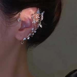 Detail of silver butterfly ear cuff with sparkling crystals worn on the earlobe