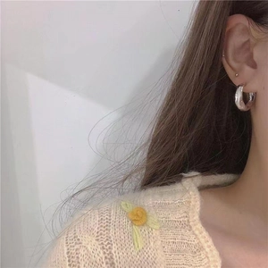 Minimalist irregular C-shaped silver stud earrings with hammered metal texture on model