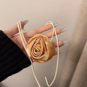 Dettaglio choker rosa in raso champagne con lunghi nastri per lo styling del collo