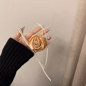 Dettaglio choker rosa in seta champagne con petali in raso e nastri morbidi per collo e vita