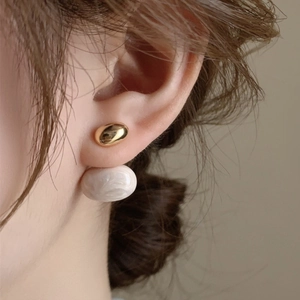 French vintage gold metal oval earrings with white marble bead on model side profile view