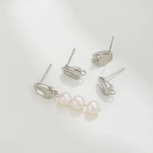 Detalle macro de pendientes de grano de café plateado con elegantes perlas blancas