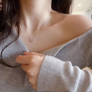 Detalle de collar con colgante de corazón hueco y pavé de circonitas en cadena fina