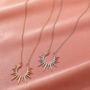 Vintage Sonnenblumen Anhänger Halsketten in Gold und Silber auf weichem Seidenhintergrund