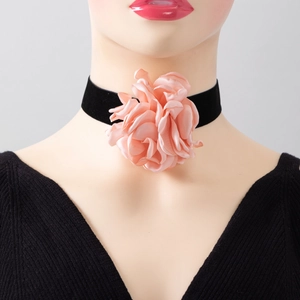Detailed view of oversized pink silk flower on a black velvet choker necklace