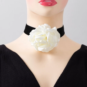 Detailed close-up of a black velvet choker featuring a large white fabric rose flower