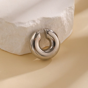 Detailed view of thick silver C-shaped ear cuff with high-polished mirror finish