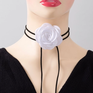Detailed close-up of a large white fabric rose flower on a long black velvet cord choker