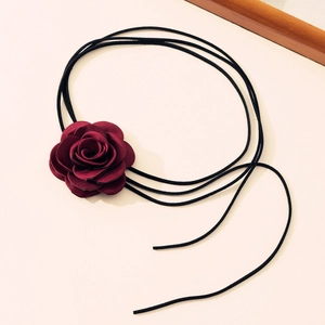 Detailed close-up of burgundy fabric rose flower on black long velvet cord choker