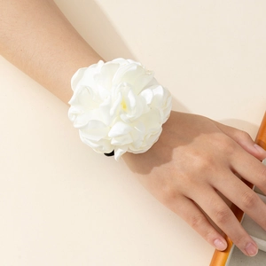 Close-up of elegant white fabric rose wrist flower with layered satin petals and black band