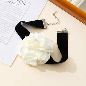 Detail of vintage black velvet choker featuring a handcrafted white fabric camellia flower
