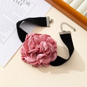 Detailed shot of a pink fabric flower choker featuring a black velvet band and lobster clasp