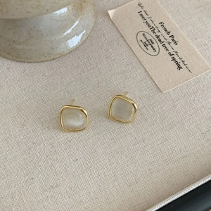 Primer plano de pendientes cuadrados de opalo con marcos dorados de diseño elegante