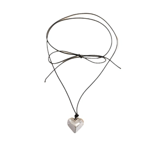 Minimalist adjustable bow wax cord choker with a silver heart pendant on white backdrop