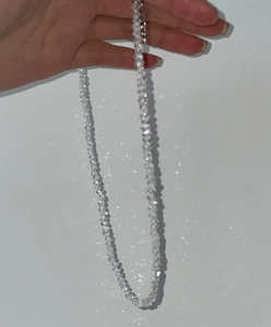 Close-up of a faceted glass crystal beaded necklace with light-refracting clear beads