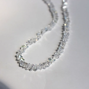 Elegant multi-faceted glass crystal bead necklace with sparkling faceted finish on white base