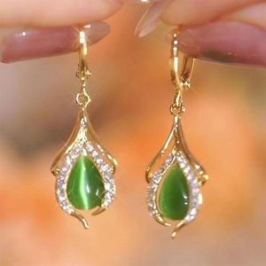 Elegant gold drop earrings featuring green cat-eye stone and teardrop-shaped zircon accents