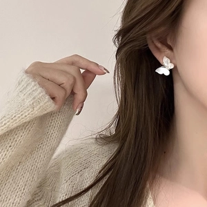 Élégantes boucles d'oreilles papillon en nacre blanche portées par un mannequin