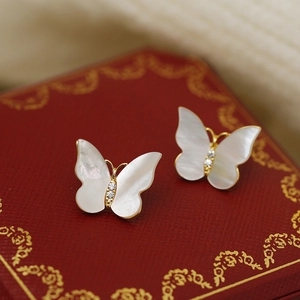 Detail of butterfly stud earrings with white mother-of-pearl and crystal inlay in a red box