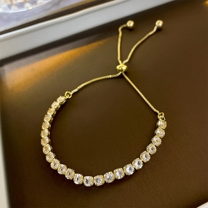 Detail of adjustable gold crystal bracelet with zircon stones and slider clasp