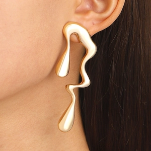Macro side view of liquid metal gold earrings showing irregular flowing lava design