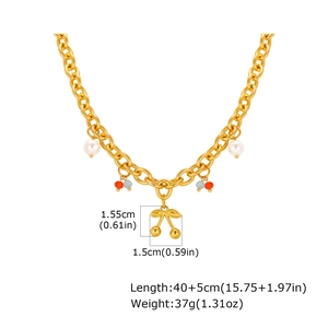 Détail du collier à maillons dorés avec pendentif cerise et perles d'imitation