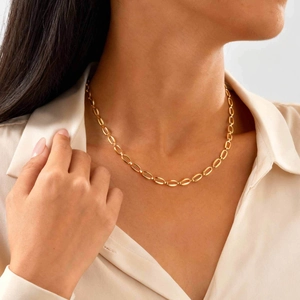Dettaglio della collana girocollo in acciaio inossidabile dorato su una modella