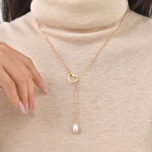 Elegant gold heart Y-necklace with teardrop freshwater pearl on a winter sweater