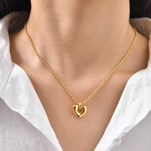 Élégant collier à pendentif cœur doré avec chaîne torsadée porté par un mannequin