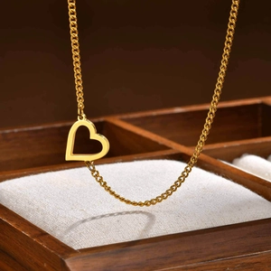 Dettaglio di una collana con ciondolo a cuore cavo dorato in una scatola per gioielli