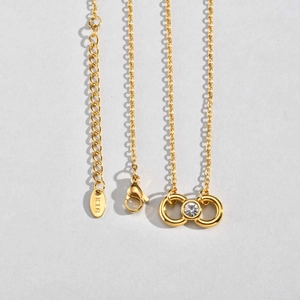 Detalle de collar infinito bañado en oro de 18K con sello K18 y cierre de mosquetón
