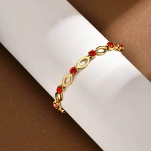 Detail of gold-plated stainless steel bracelet with oval links and red rhinestones