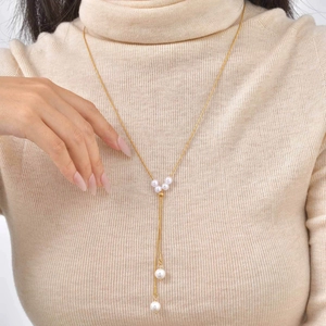 Elegant 18K gold-plated Y-shaped necklace with white pearls on a knitted sweater