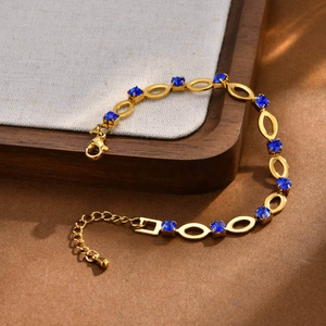Macro detail of gold-plated stainless steel chain with blue square zircon and lobster clasp