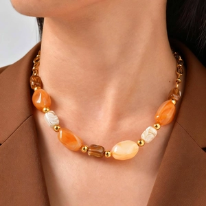 Maillard-style necklace with brown oval beads and gold metal accents on model
