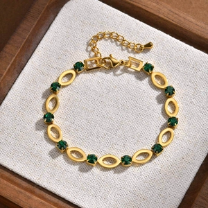 Detail of gold plated stainless steel bracelet with green stones and oval hollow links