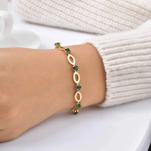 Elegant gold plated stainless steel bracelet with oval hollow links and green zircon stones