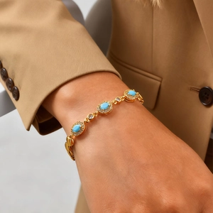 Dettaglio del bracciale placcato oro 24K con pietre ovali blu e zirconi indossato al polso