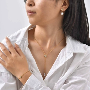 Parure de bijoux trèfle doré avec collier, bracelet et boucles d'oreilles sur mannequin