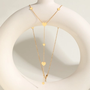Elegant gold Y-shaped stainless steel necklace with sleek heart charms on a white stand