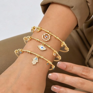 Golden snake chain bracelet set with evil eye and Hamsa hand pendants in zircon