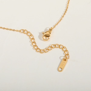 Detail of lobster clasp and adjustable extension chain with K18 engraved metal tag