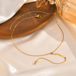 Collana a Y in acciaio inossidabile dorato con dischi lucidi su elegante sfondo di seta bianca